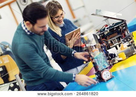 Young Attractive Students Of Mechatronics Working On Project