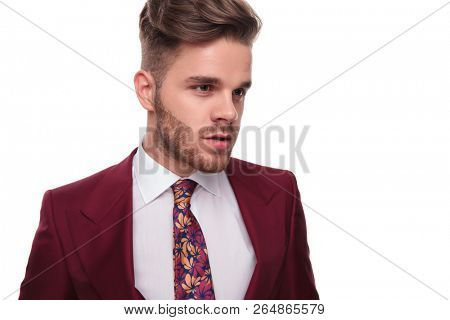 portrait of surprised man in grena suit looking down to side with mouth open