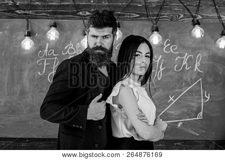 Teacher And Strict Schoolmaster Look Confident. Lady And Hipster Working Together In School. Man Wit