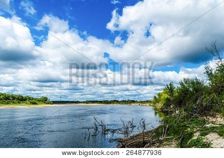 A Wide River Flows Along A Diagonal Bank With A Forest Under An Incredibly Beautiful Blue Sky With L
