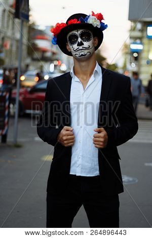 A Man With A Painted Face Of A Skeleton, A Dead Zombie, In The City During The Day. Day Of All Souls