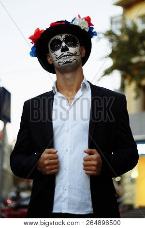 A Man With A Painted Face Of A Skeleton, A Dead Zombie, In The City During The Day. Day Of All Souls