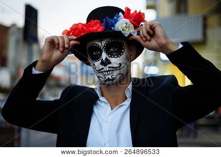 A Man With A Painted Face Of A Skeleton, A Dead Zombie, In The City During The Day. Day Of All Souls