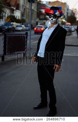 A Man With A Painted Face Of A Skeleton, A Dead Zombie, In The City During The Day. Day Of All Souls