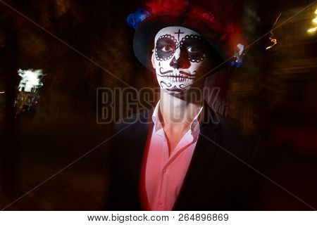 A Man With A Painted Face Of A Skeleton, A Dead Zombie, In The City During The Day. Day Of All Souls