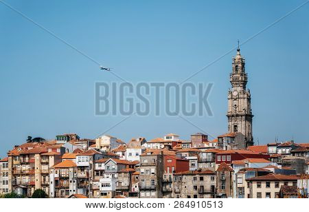 Porto Cityscape With Clerigos Tower And Airplane In Blue Sky, Portugal