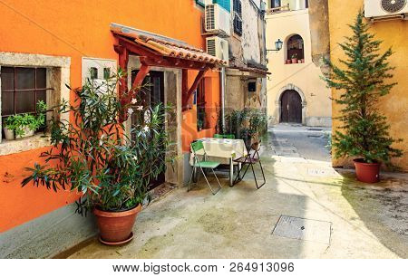 Lovran, Croatia. Cosy streets of ancient old town with vintage buildings and small cafes and restaurants. Sunny summer day. Urban landscape of historical centre.