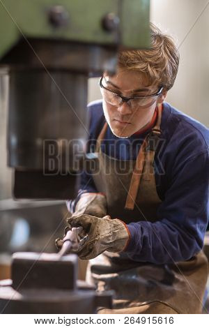Young Blaksmith Working With Hot Metal In A Workshop