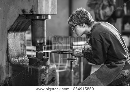 Young Blaksmith Working With Hot Metal In A Workshop