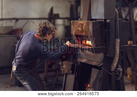 Young Blaksmith Working In A Metalworking Workshop
