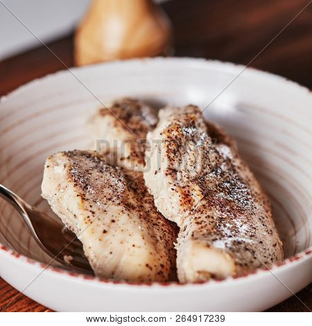 Cooked chicken meat with spices in a ceramic bowl and fork. Dietary Ingredient for salad