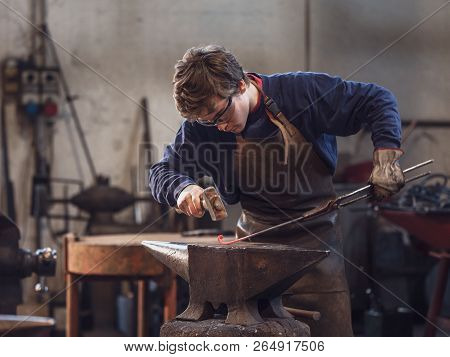 Young Blacksmith Working With Red Hot Metal
