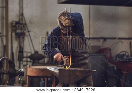 Young Blacksmith Working With Red Hot Metal