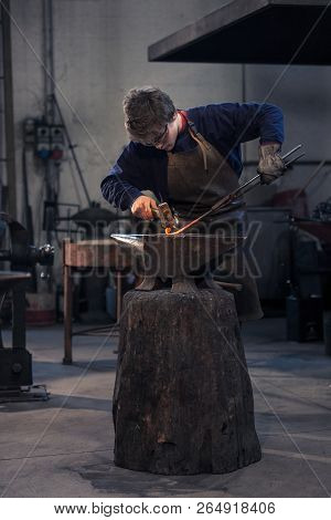 Young Blacksmith Working With Red Hot Metal