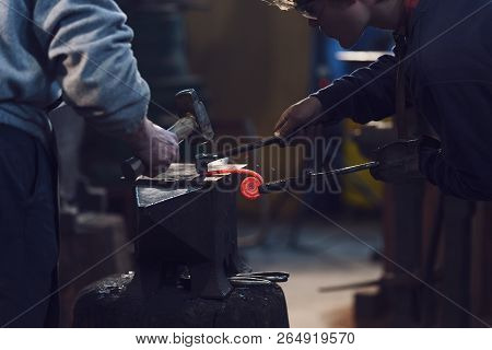 Two Men Working In A Metalworking Workshop