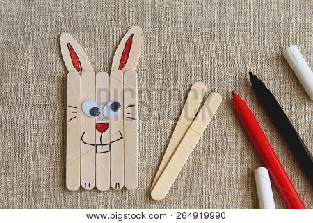 Fun Easter Bunny Made Of Wooden Sticks And Felt-tip Pens On Rough Canvas.