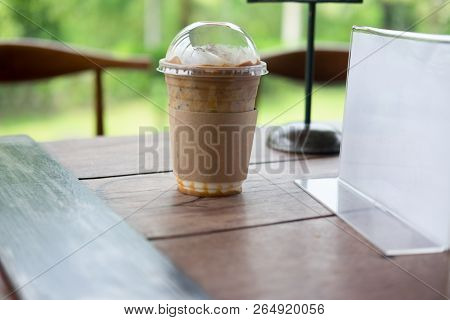 Ice Caramel Mochiato Put On Wooden Table In Coffee Shop