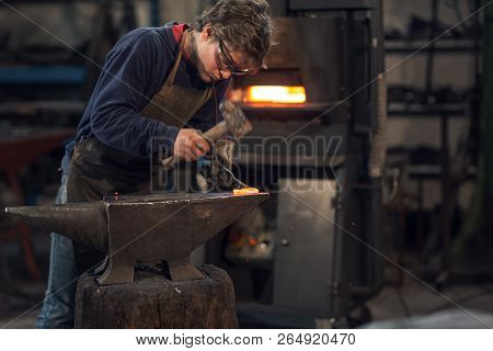 Young Blacksmith Working With Red Hot Metal