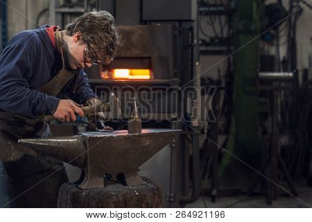 Young Blacksmith Working With Red Hot Metal