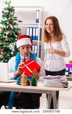 Colleagues exchaing christmas presents in office