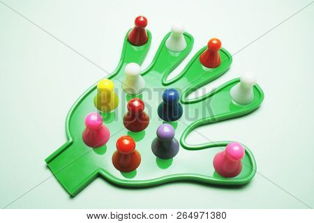 Game Pieces On Plastic Hand With Green Background