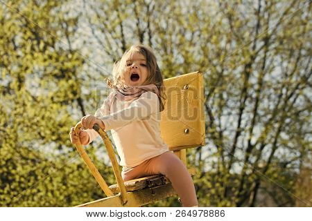 Happy Child Have Fun On Playground. Girl Sit On Seesaw On Sunny Day. Kid On Teeter Totter Outdoor. B