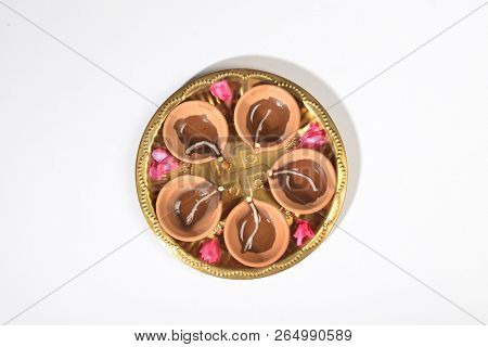 Typical non decorative Diwali earthen lamps arranged in a plate. View from top. Isolated Indian festive object.
