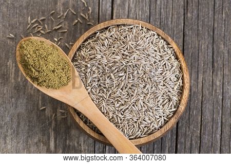 Pile Of Dry Caraway Spice With Ground Caraway Powder In Wooden Spoon. Healthy Food Cumin Spice Conce