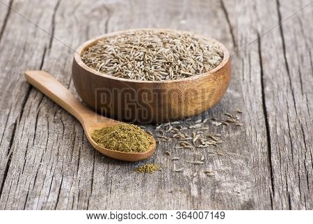 Pile Of Dry Caraway Spice With Ground Caraway Powder In Wooden Spoon. Healthy Food Cumin Spice Conce