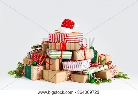 Piggy Bank In Santa Claus Hat. Christmas Gift Boxes. White Background. The Concept Of Saving.