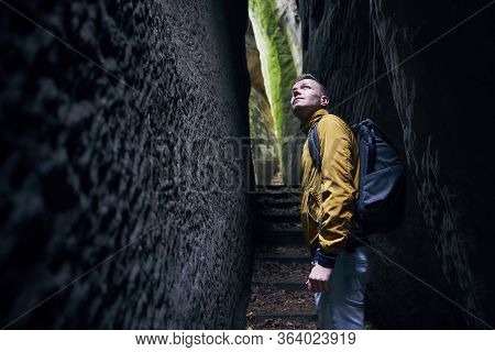 Traveler In Narrow Footpath Looking Up To Rock Formations. Hruba Skala In Bohemian Paradise, Czech R