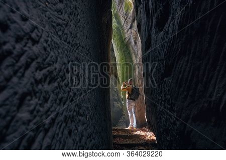 Photographer In Narrow Footpath Looking Up To Rock Formations. Hruba Skala In Bohemian Paradise, Cze