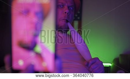 Cute Man Smoking Hooka Shoots Selfie Or Streaming Video With A Phone, Man Has Fun At Home During Per
