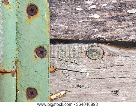 Fragment Of A Rustic Gate In A Fence Close-up. Old Gray Weathered Wooden Beams And Door Hinge. Vinta