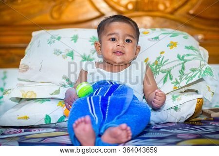 A Asian Baby Boy Is Looking And Playing At Colorful Toys.