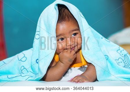 A Six Months Age Asian Baby Boy Playing A Yellow Taddy Bear.