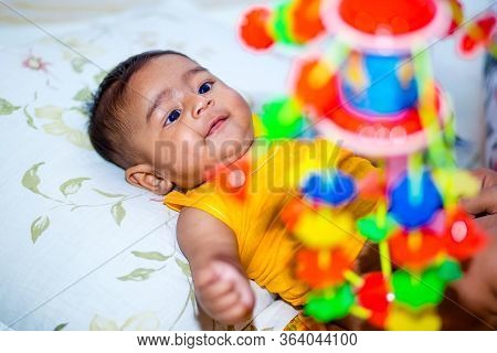 A Six Months Age Asian Baby Boy Playing A Yellow Taddy Bear.