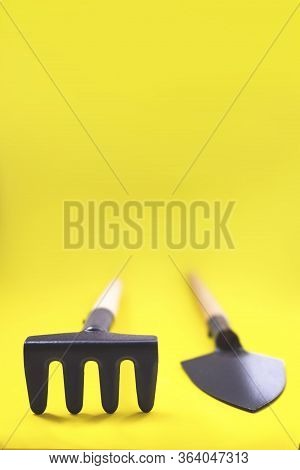 Gardening Tools On Yellow Background. The Concept Of Environmental Stewardship And World Environment