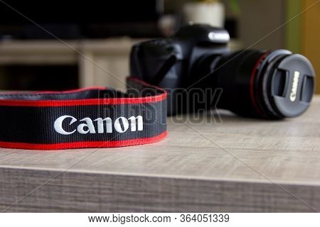 Brecht, Belgium - April 30 2020: A Close Up Portrait Of A Blurred Canon Dslr Camera On A Wooden Tabl
