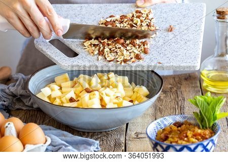 Grinds hazelnuts. A cook grinds a nut on a board with a knife. Hazelnuts on the board. stuffing with