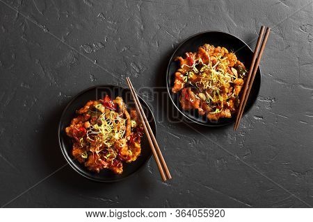 Spicy Garlic Fried Chicken (kkanpunggi). Asian Chicken In Sweet And Sour Sauce On Plate Over Black S