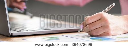 Table At Home Laptop And Documents, Female Hands. Inscription On Documents, Statistical Report. Mode