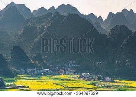 Rapeseed Flower Field And Villages At Wanfenglin  National Geological Park (forest Of Ten Thousands
