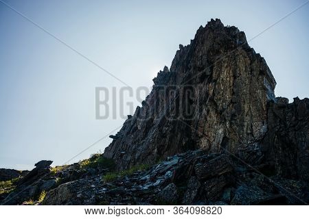 Silhouette Of Big Rock. Great Pointy Stone Among Greenery On Mountain Top In Sunny Day. Vivid Grasse