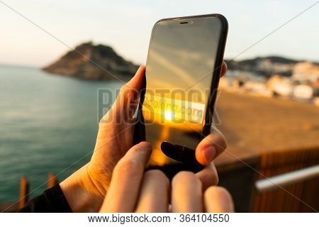Hands holding iPhone 11 with an app of booking.com service. Holidays and vacation concept. A woman f