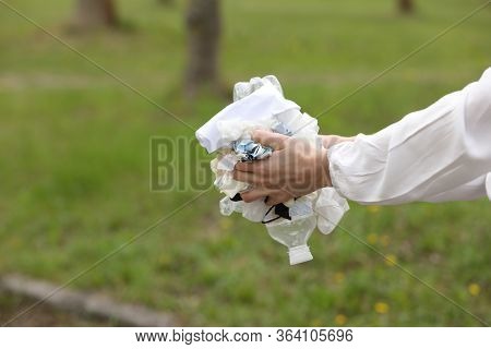 Woman Throws Plastic Garbage In The Trash. Woman Hand Picking Up Garbage Plastic For Cleaning At Par