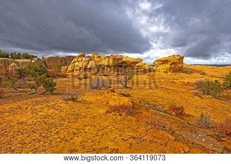 Sun Breaking Through The Clouds On A Colorful Sandstone Ridge In El Malpais National Monument In New
