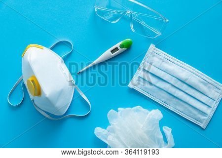 Medical Protective Mask, Respirator Ffp, Rubber Gloves, Thermometer And Protective Glasses Lie On A 