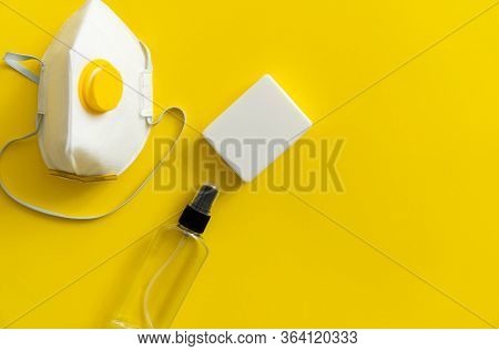 Protective Mask, Respirator Ffp, Soap And Antiseptic Lie On A Yellow Background. Anti-virus Protecti