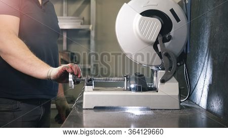 Metal Grinding Machine In Work. Worker Sawing Steel. Manufacturing Industry Concept.